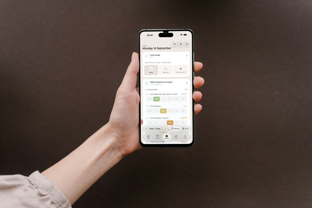 Hand houdt een telefoon vast waarop de 21 DRSP-symptomen van de dag worden gescoord in PMDD Tracker.